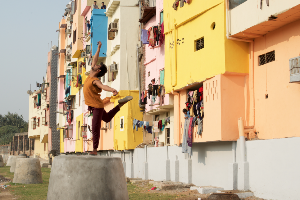 Dancer in front of colourful houses in Delhi