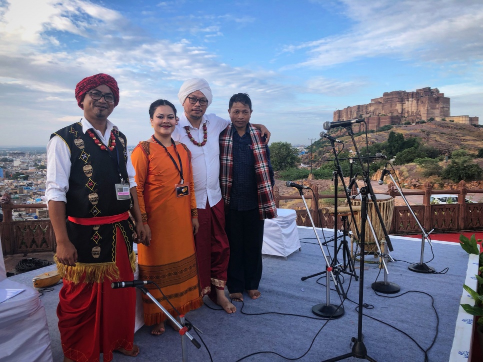 4 musicians onstage with a beautiful fort in the background, Jodhpur, India