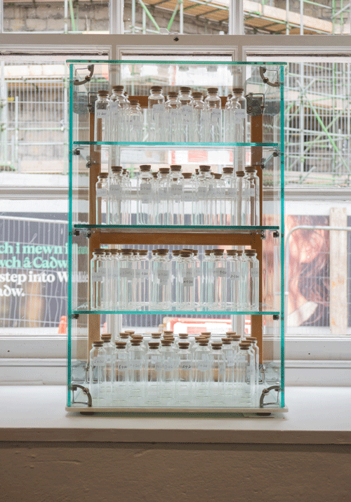 3 shelves full of bottles of air by artist Sarah Holyfield