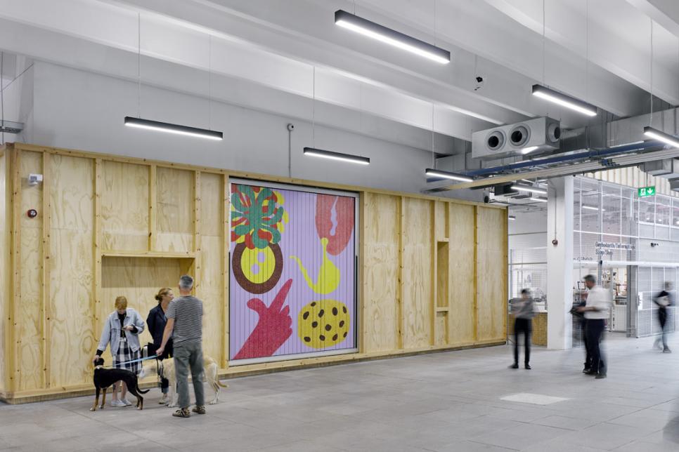 Interior shot if Ty Pawb in Wrexham, showing people, artwork and two dogs.