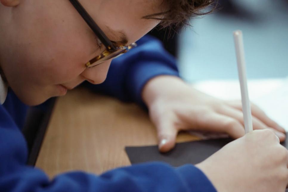 Child writing on a notepad.