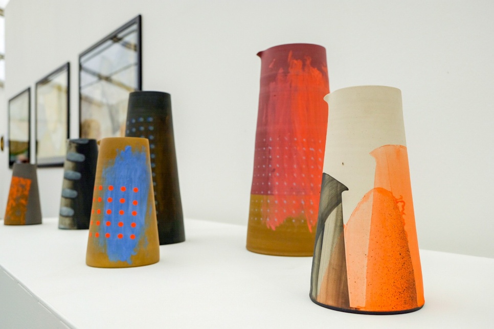 A row of pots on a sill in a gallery