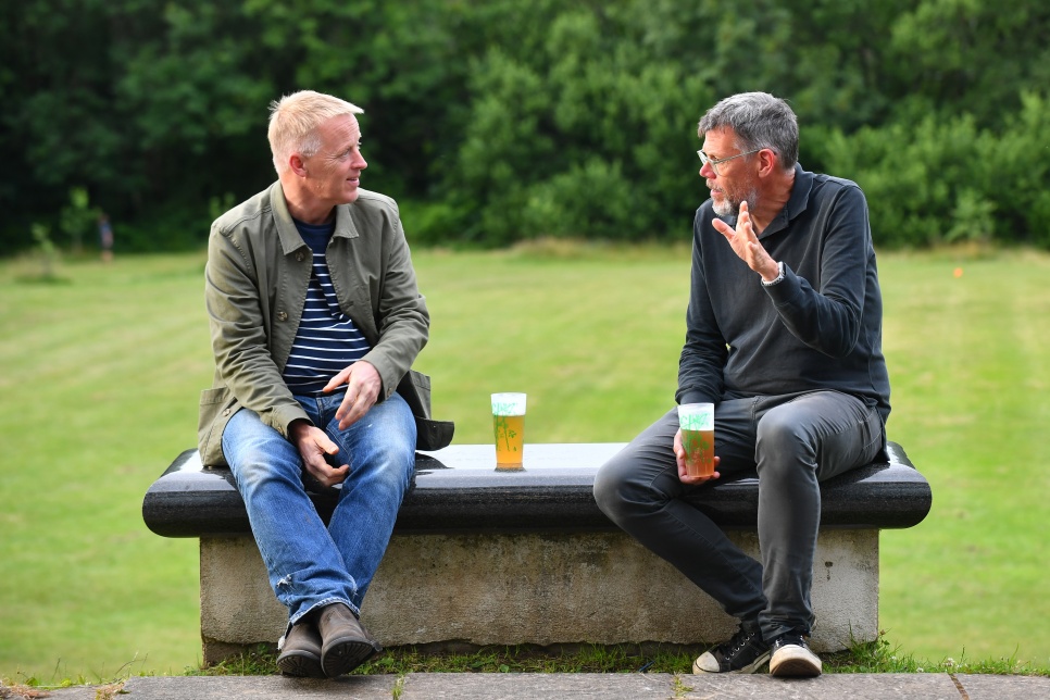 Pete Gregory of Night Out sitting on a bench with another man