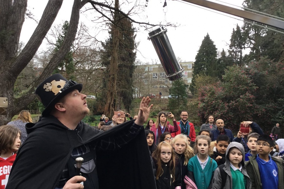 School children looking up at a metal object