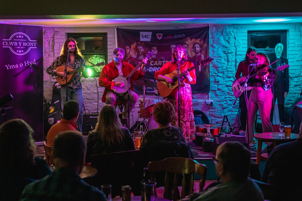 Band yn chwarae ar lwyfan | A band playing on stage