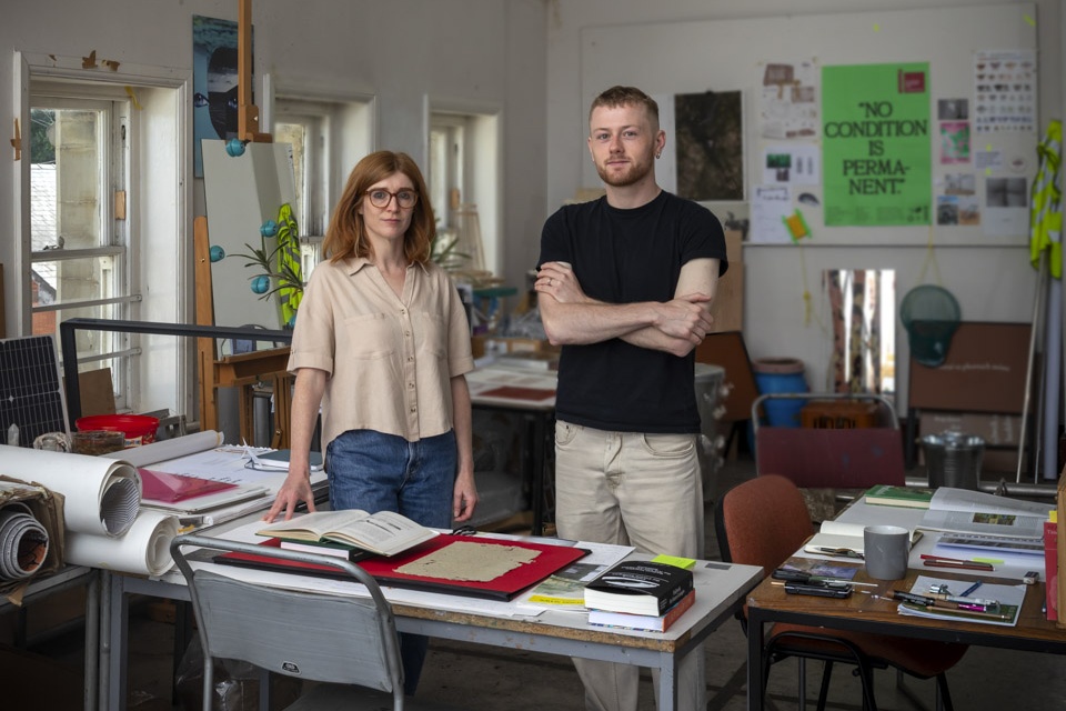 Two people standing in a workshop